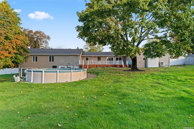 back of house featuring a lawn and a fenced in pool