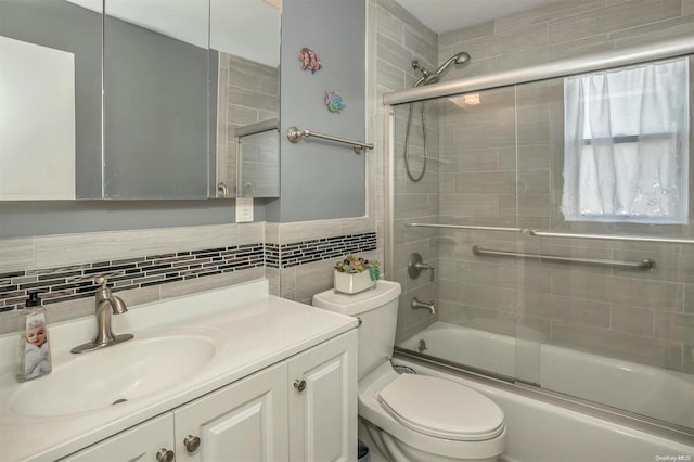 full bathroom with vanity, toilet, shower / bath combination with glass door, and backsplash