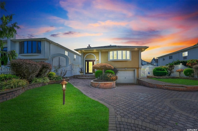 view of front facade featuring a garage, a yard, and french doors