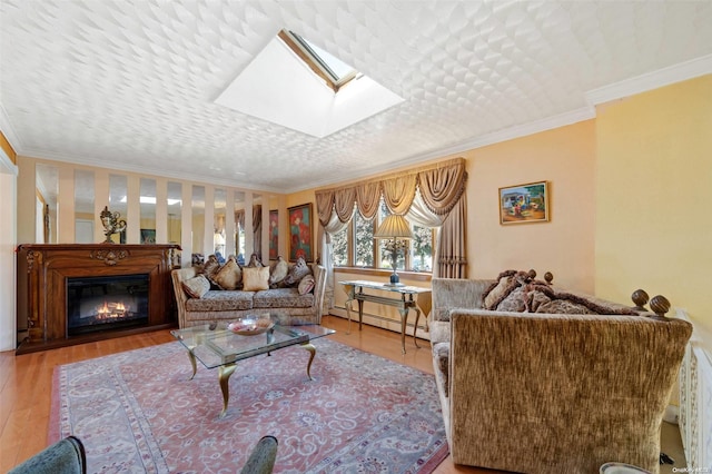 living room featuring light wood-type flooring, a skylight, crown molding, and a baseboard heating unit