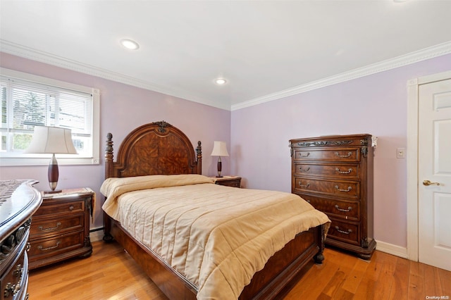 bedroom with a baseboard heating unit, crown molding, and light hardwood / wood-style flooring