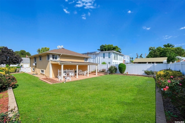 rear view of house featuring a patio and a lawn