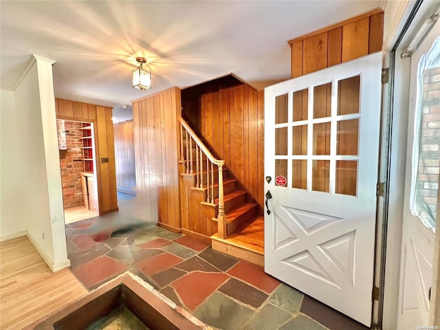 entrance foyer with wood walls and dark hardwood / wood-style floors