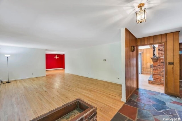 living room featuring hardwood / wood-style flooring, wood walls, and baseboard heating