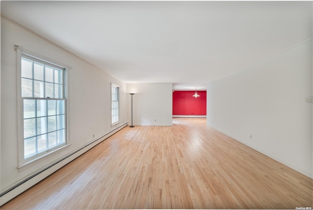 spare room with wood-type flooring and a baseboard radiator