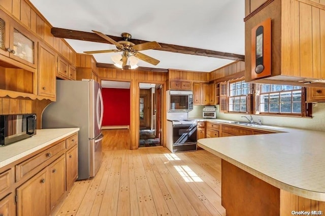 kitchen featuring beam ceiling, ceiling fan, light hardwood / wood-style flooring, kitchen peninsula, and appliances with stainless steel finishes