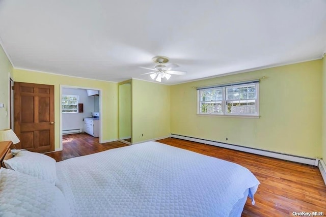 bedroom with hardwood / wood-style flooring, ceiling fan, and baseboard heating