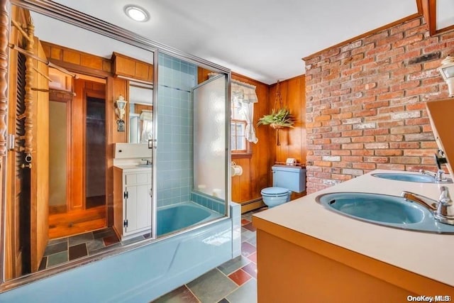 full bathroom with vanity, a baseboard radiator, toilet, and bath / shower combo with glass door