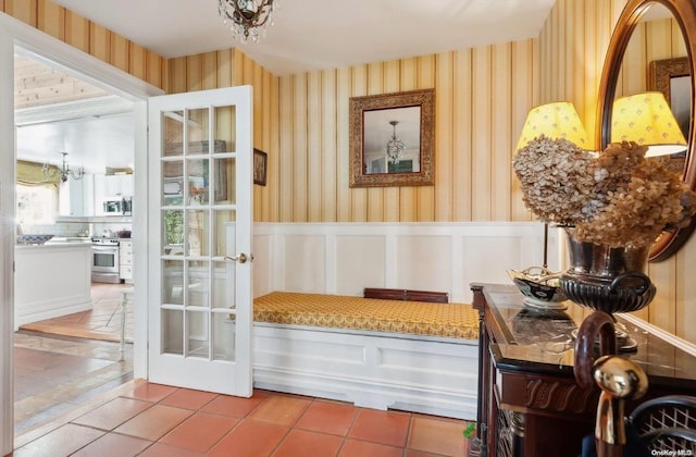 doorway to outside with tile patterned flooring and a chandelier