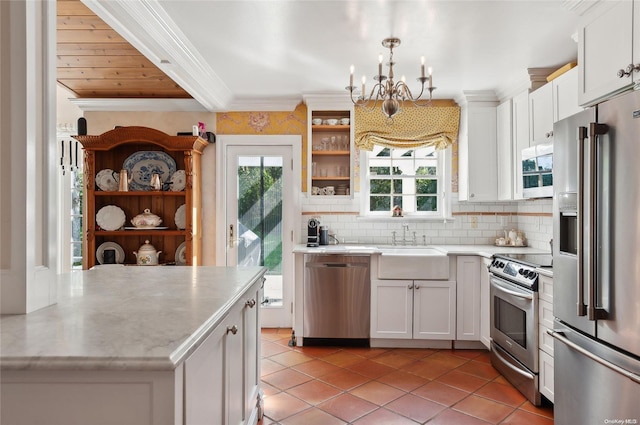 kitchen with white cabinets, hanging light fixtures, decorative backsplash, appliances with stainless steel finishes, and light tile patterned flooring