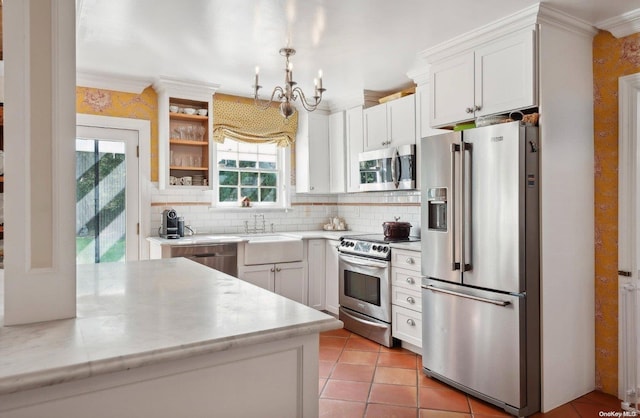 kitchen with stainless steel appliances, white cabinetry, and a healthy amount of sunlight