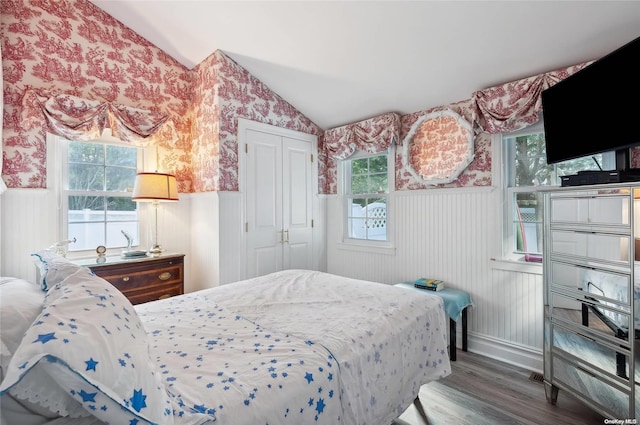 477 Montauk Hwy, Westhampton Beach, NY 11978 - bedroom with wallpapered walls, wood finished floors, a wainscoted wall, vaulted ceiling, and a closet