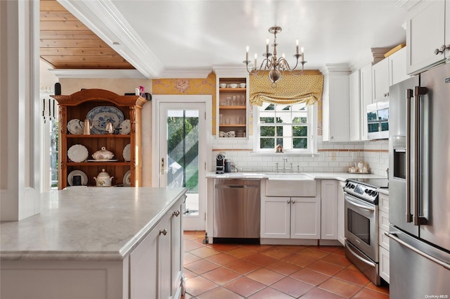 kitchen with a sink, light tile patterned flooring, a notable chandelier, light countertops, and appliances with stainless steel finishes