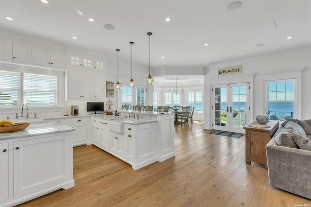 kitchen with white cabinets, pendant lighting, a healthy amount of sunlight, and sink