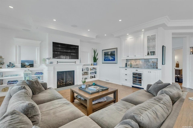 living room featuring wine cooler, crown molding, and light hardwood / wood-style floors