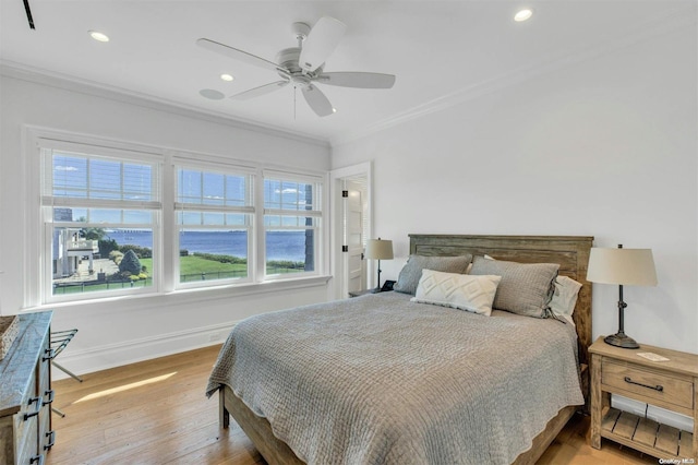 bedroom featuring light hardwood / wood-style flooring, ceiling fan, and ornamental molding