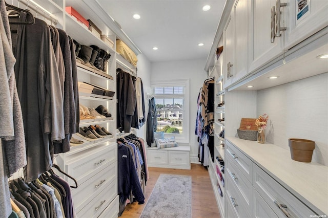 walk in closet with light hardwood / wood-style floors