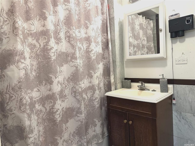 bathroom with vanity and tile walls