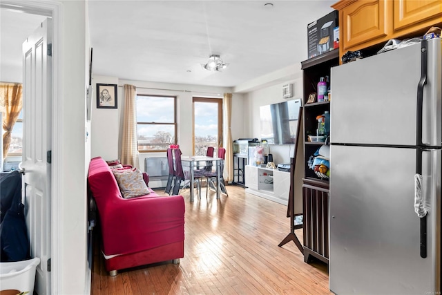 kitchen with stainless steel refrigerator and light hardwood / wood-style flooring