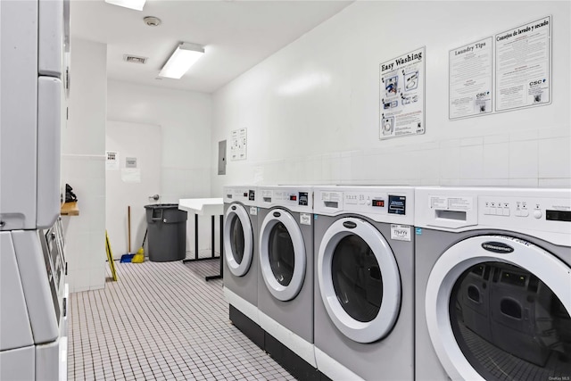 laundry area featuring tile walls, tile patterned floors, and washer and dryer