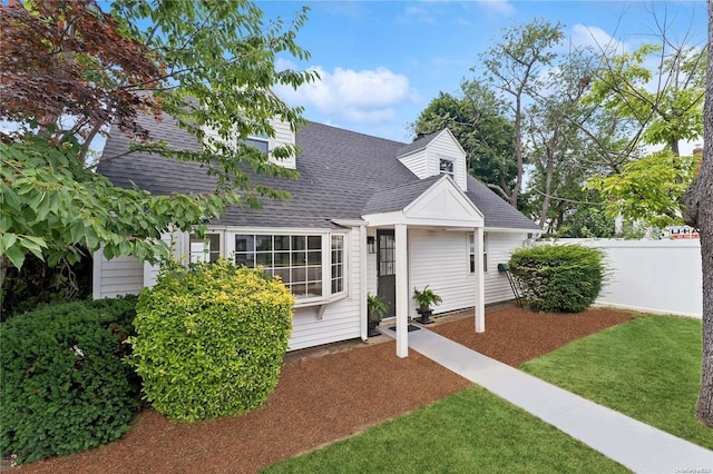 cape cod house with a front lawn