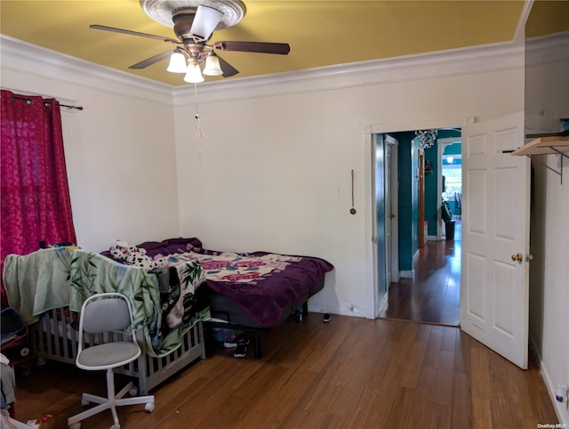 bedroom with ceiling fan, dark hardwood / wood-style flooring, and ornamental molding