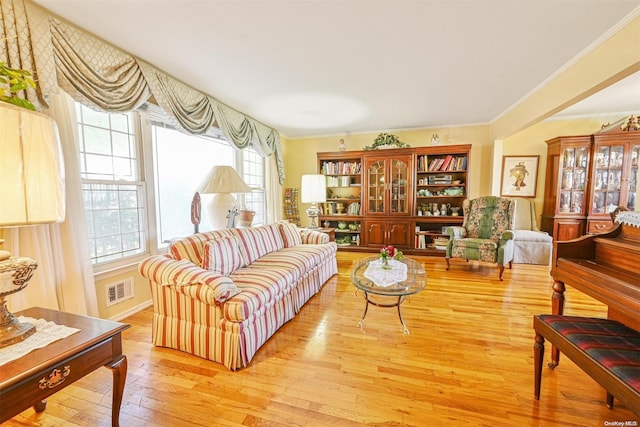 living room featuring light wood-type flooring and crown molding