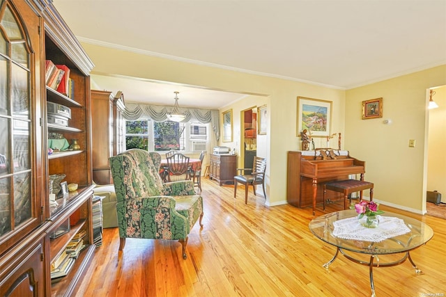 living room with crown molding and light hardwood / wood-style flooring