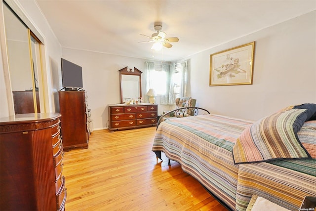 bedroom with ceiling fan, a closet, and light hardwood / wood-style flooring