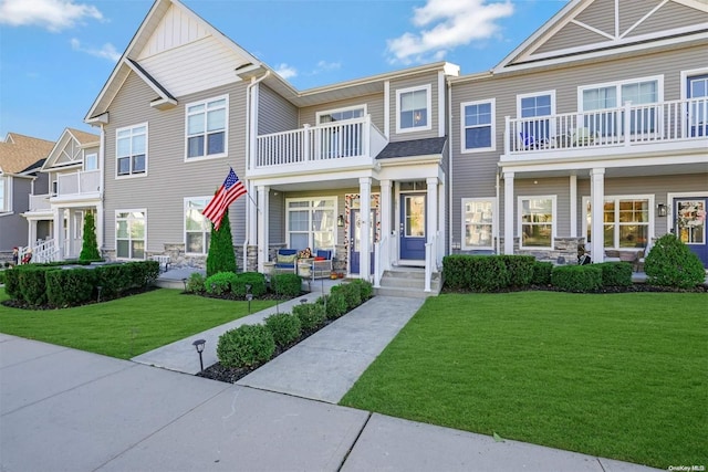 view of front of home with a front yard and a balcony