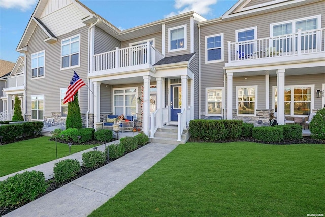 townhome / multi-family property featuring a front yard and a balcony