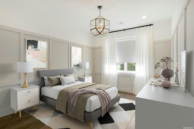 bedroom featuring light wood-type flooring and a notable chandelier