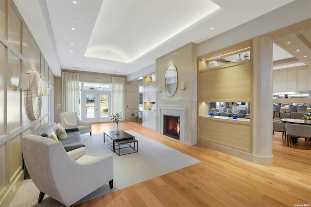 living room with a tray ceiling and hardwood / wood-style flooring