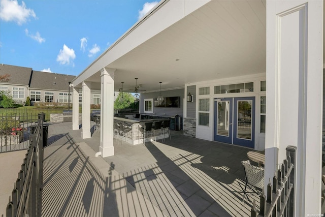 view of patio / terrace with french doors, an outdoor kitchen, an outdoor bar, and ceiling fan