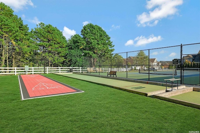 view of community with a yard and tennis court