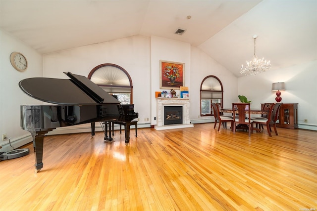 living area with hardwood / wood-style floors, a notable chandelier, and lofted ceiling