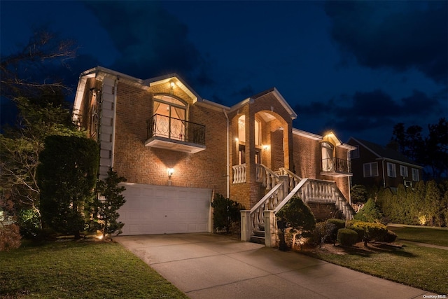 view of front of house featuring a yard, a balcony, and a garage