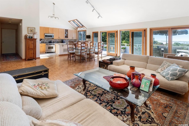 living room featuring light parquet floors, track lighting, and high vaulted ceiling