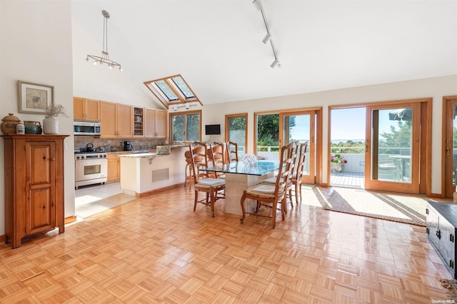 dining room with light parquet floors, track lighting, high vaulted ceiling, and a skylight