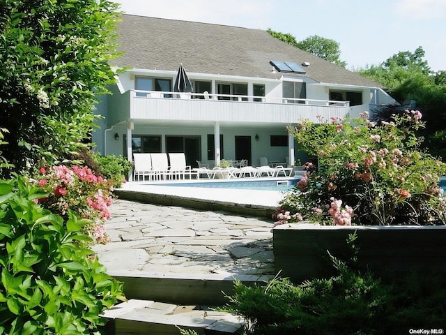 rear view of house featuring a patio and a balcony