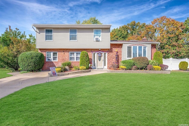 tri-level home with cooling unit and a front lawn