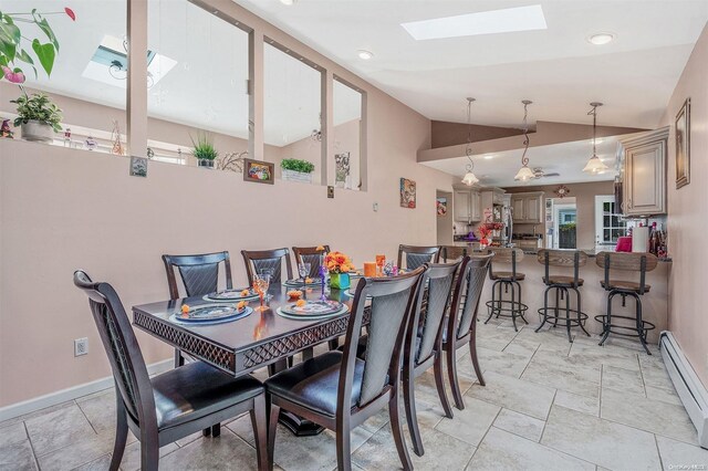 dining area featuring vaulted ceiling with skylight and a baseboard heating unit