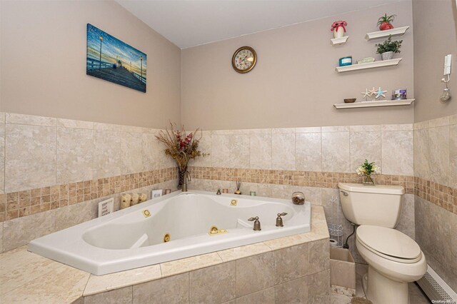 bathroom featuring tiled tub and toilet