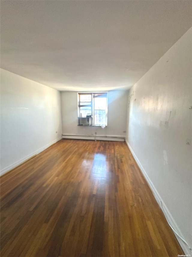 spare room featuring dark hardwood / wood-style floors and baseboard heating