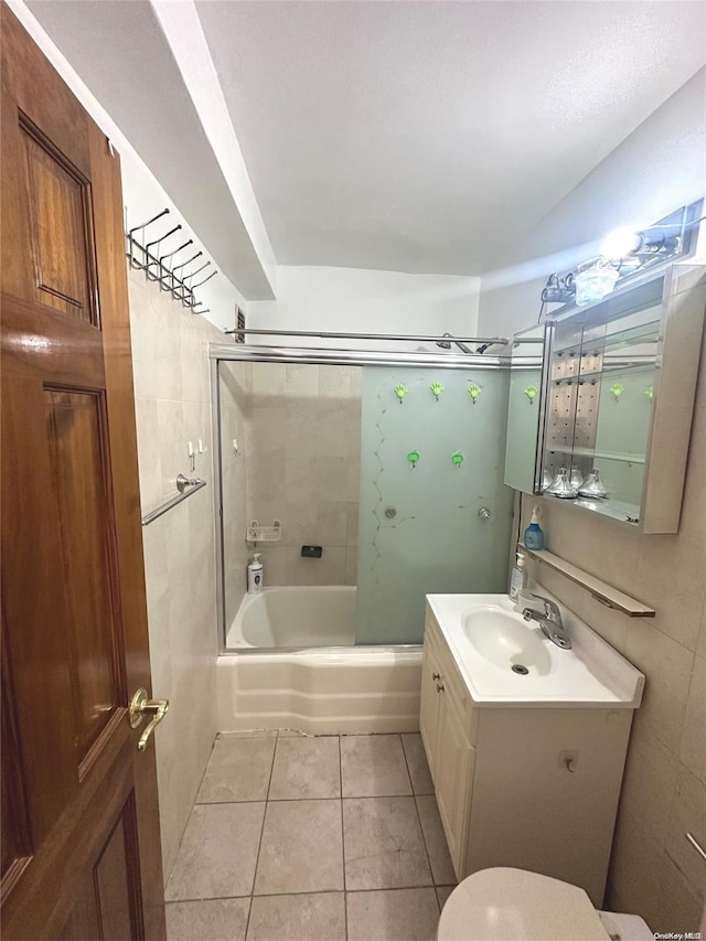 full bathroom with tile patterned flooring, vanity, tiled shower / bath combo, and toilet