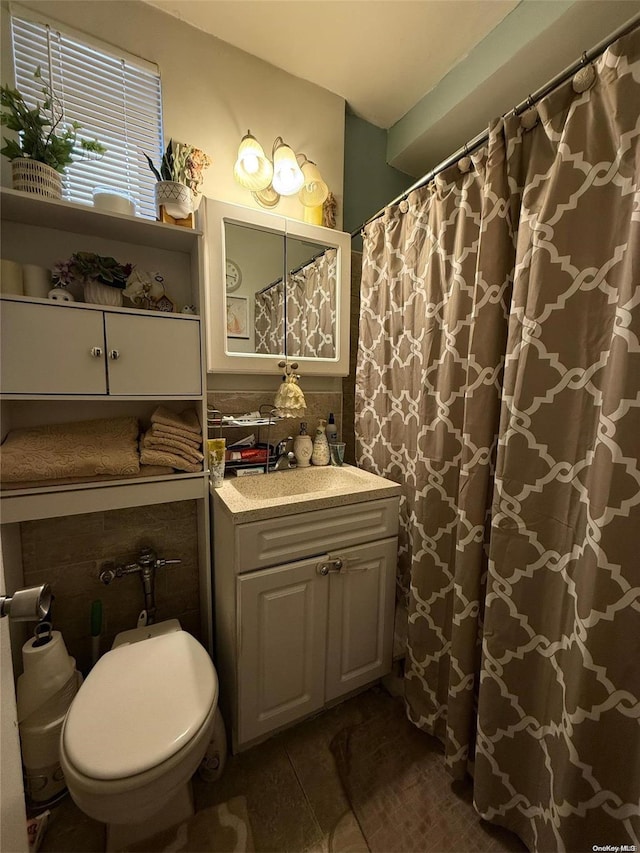 bathroom featuring tile patterned flooring, vanity, toilet, and backsplash