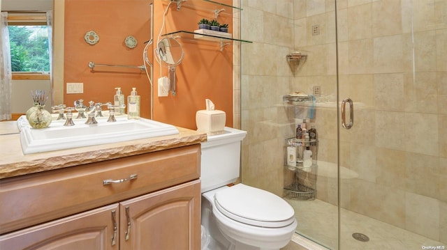 bathroom featuring vanity, an enclosed shower, and toilet