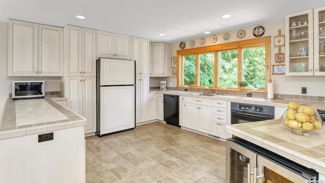 25 Oceanview Dr, Southampton, NY 11968 - kitchen featuring recessed lighting, a sink, black appliances, and wine cooler