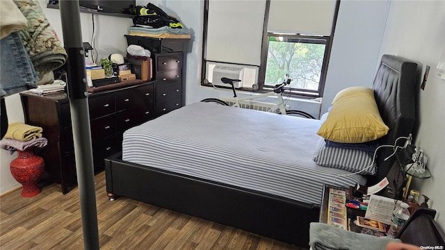 bedroom with cooling unit and wood-type flooring