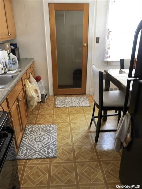 interior space featuring sink, black range oven, and fridge